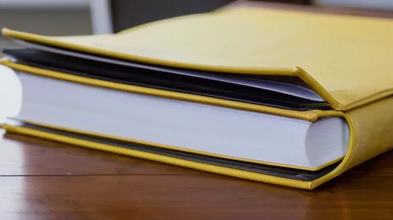 Una máquina de escribir antiguas, con notas y documentos apilados en un escritorio antiguo bajo la tenue luz del día
