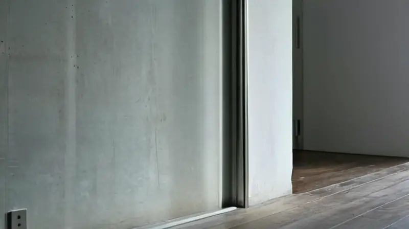 La habitación presentaba un toque minimalista con una pared de hormigón gastado donde se reflejaba la luz de otra ventana