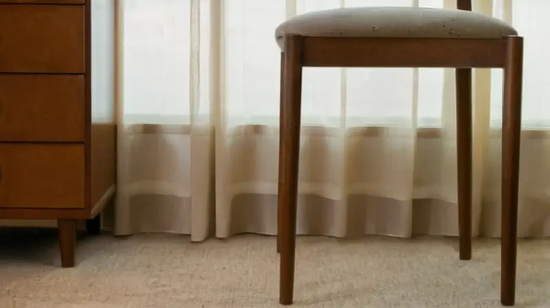 Una silla de escritorio gastada y desgastada estaba en el borde de una mesa cubierta con un montón de cosas